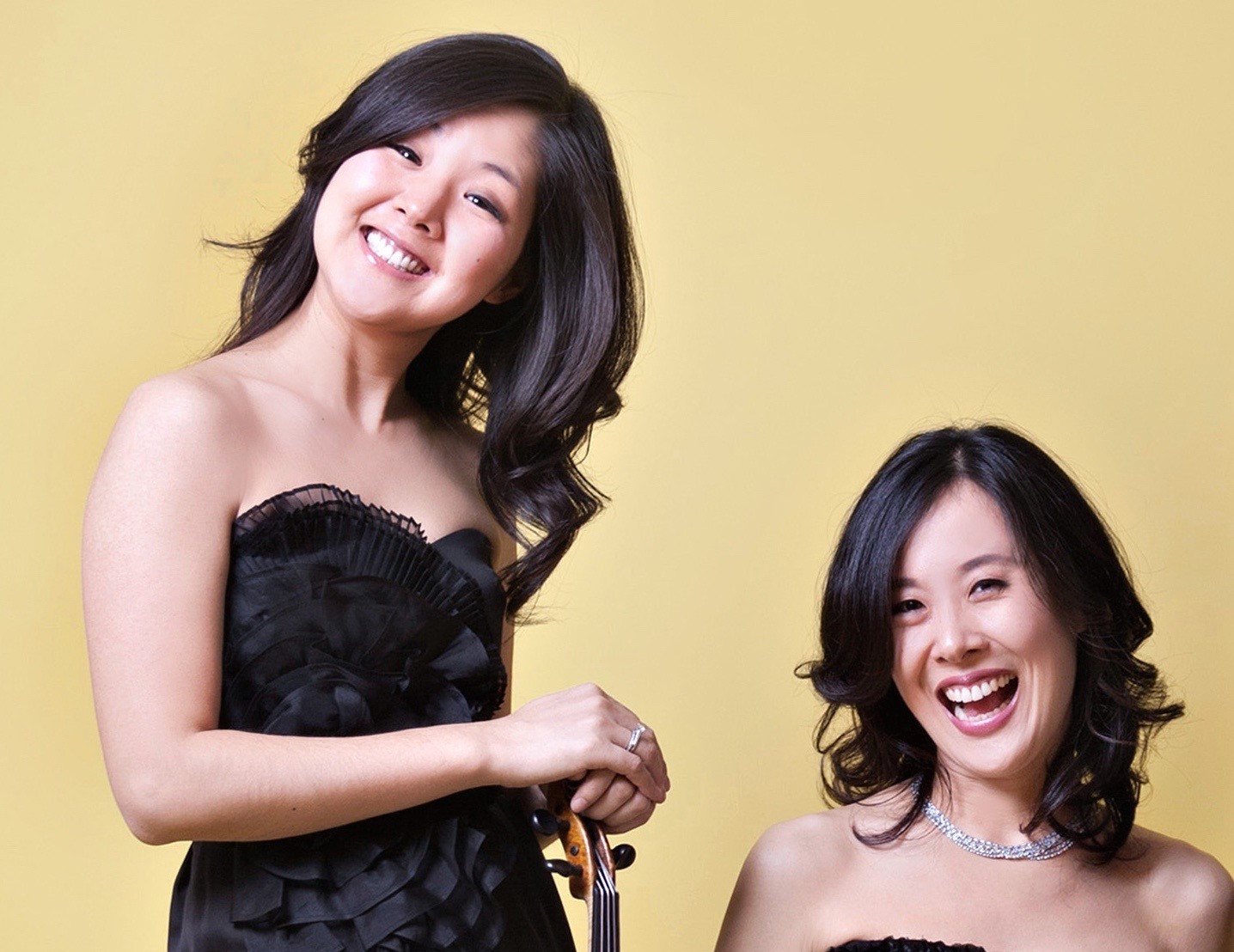 Violinist Min-Jeong Koh and Pianist Bo-Yon Koh smile in a publicity photo