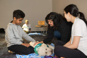 Two audience members, a mother and son, meet with one of One Health Partners' therapy dogs and their handler.